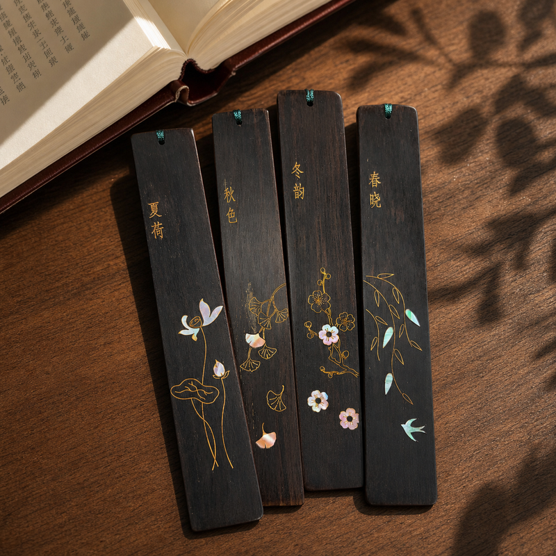 Four Seasons shell-inlay bookmark set on a warm walnut reading desk